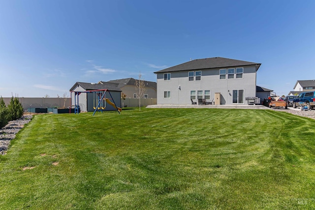 3539 W Zarea Dr, Meridian, ID 83642 - back of house with a lawn, a patio, a fenced backyard, and a playground