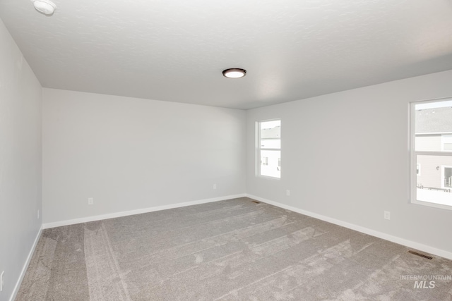 19361 James Ave, Caldwell, ID 83605 - carpeted spare room featuring visible vents, baseboards, a textured ceiling, and a healthy amount of sunlight