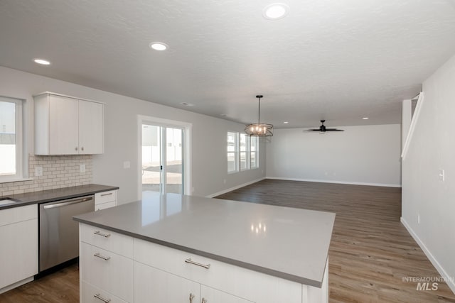 19361 James Ave, Caldwell, ID 83605 - kitchen with wood finished floors, white cabinetry, decorative backsplash, dishwasher, and dark countertops