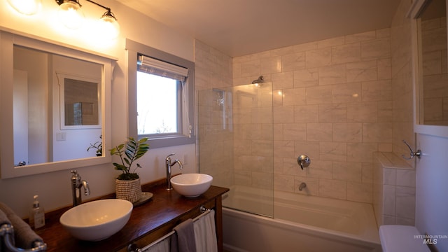 bathroom featuring double vanity, shower / washtub combination, and a sink