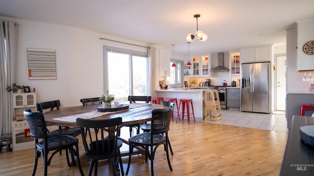 dining area with light wood finished floors and an inviting chandelier