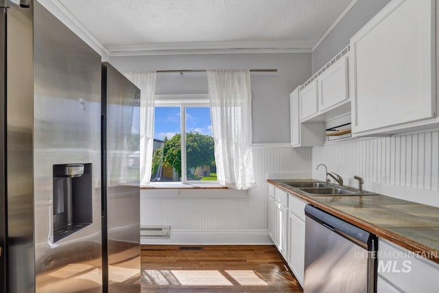 712 Yakima Ave, Filer, ID 83328 - kitchen with appliances with stainless steel finishes, a sink, dark wood-style floors, white cabinetry, and ornamental molding