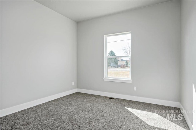 spare room with visible vents, baseboards, and carpet floors