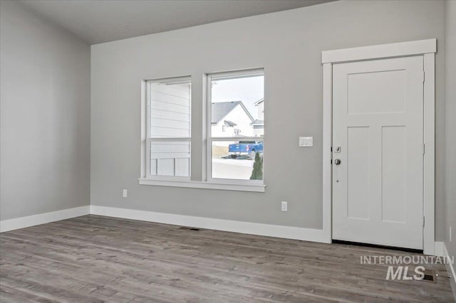 foyer with visible vents, baseboards, and wood finished floors