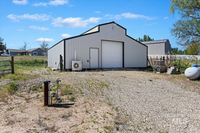 view of outbuilding featuring ac unit, fence, an outbuilding, and gravel driveway