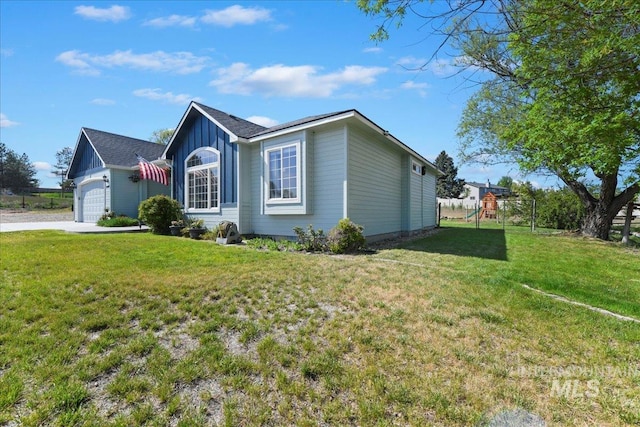 view of home's exterior with board and batten siding, a playground, a yard, an attached garage, and concrete driveway