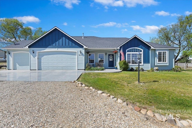 ranch-style home featuring a garage, board and batten siding, driveway, and a front lawn