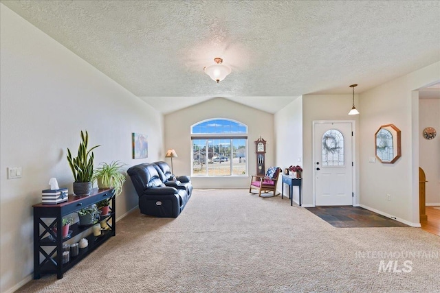 carpeted foyer with baseboards, a textured ceiling, and vaulted ceiling