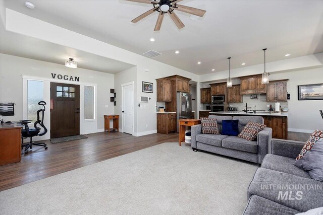 living room with baseboards, visible vents, dark wood-type flooring, and recessed lighting