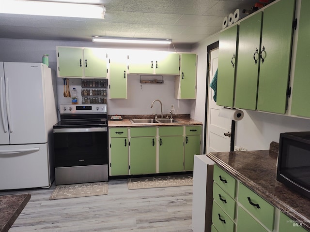 kitchen with sink, stainless steel electric range oven, green cabinetry, and white fridge