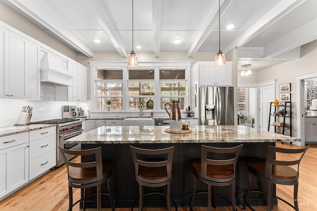 733 W Cowman St, Eagle, ID 83616 - kitchen with appliances with stainless steel finishes, a center island, beamed ceiling, backsplash, and white cabinetry