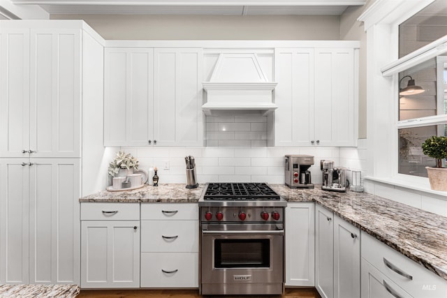 733 W Cowman St, Eagle, ID 83616 - kitchen with premium stove, premium range hood, decorative backsplash, and white cabinetry