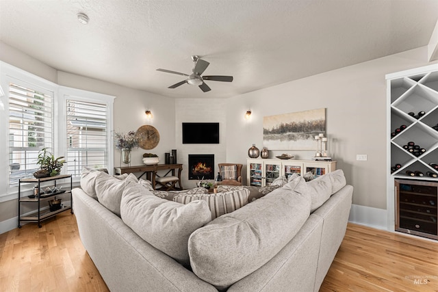 733 W Cowman St, Eagle, ID 83616 - living room featuring wine cooler, a ceiling fan, light wood finished floors, and a large fireplace