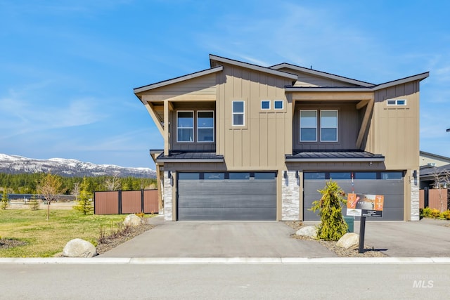 11 N Creek Way, Cascade, ID 83611 - view of front of home with a standing seam roof, a garage, a mountain view, fence, and asphalt driveway