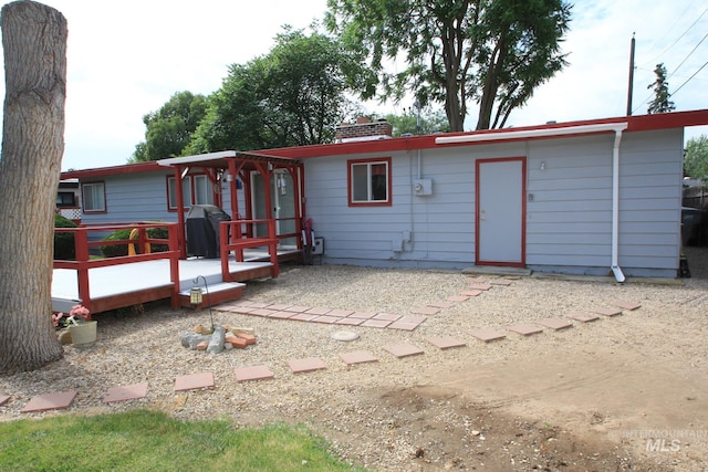 7644 W Cambridge Dr, Boise, ID 83704 - rear view of house featuring a wooden deck and a chimney