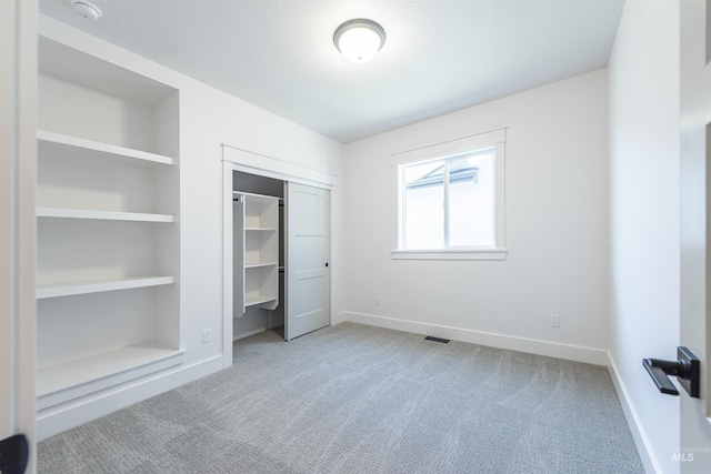 unfurnished bedroom featuring carpet floors, a closet, visible vents, and baseboards