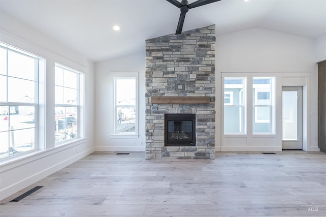 unfurnished living room with lofted ceiling, light wood-style floors, a fireplace, and visible vents