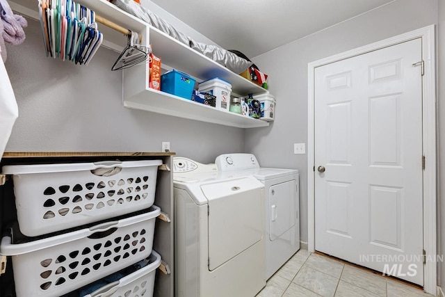 laundry room with light tile patterned floors, washer and dryer, and laundry area