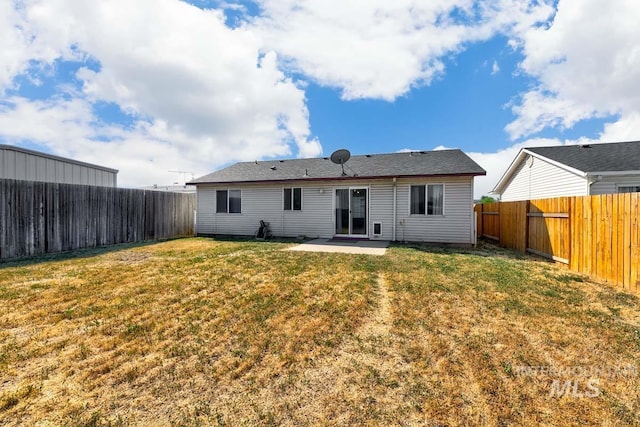 back of property featuring a yard, a fenced backyard, and a patio area
