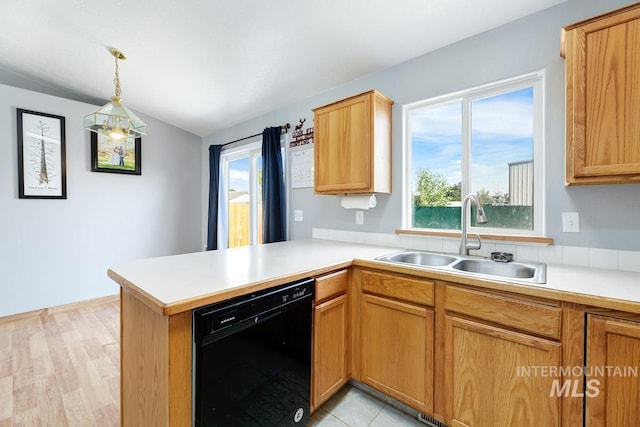 kitchen with vaulted ceiling, a peninsula, light countertops, dishwasher, and a sink