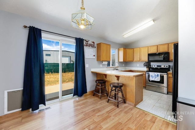 kitchen with a sink, a peninsula, electric stove, black microwave, and lofted ceiling