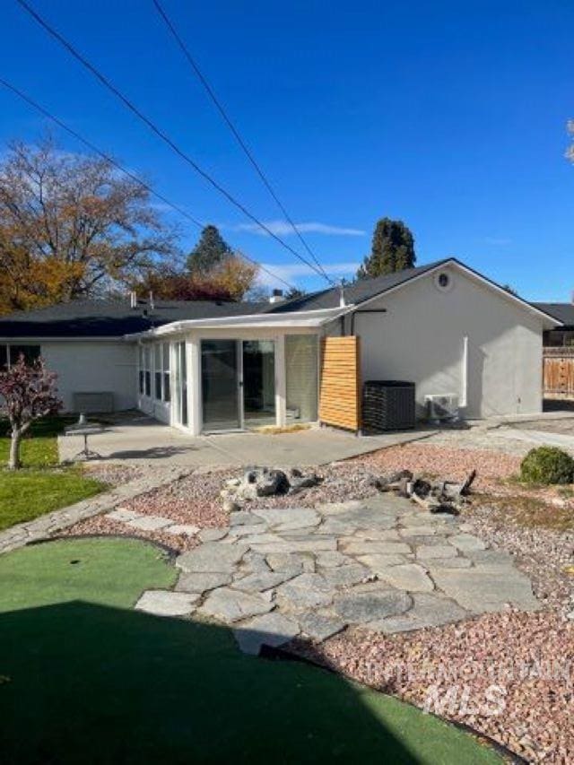 rear view of property featuring a lawn and a patio