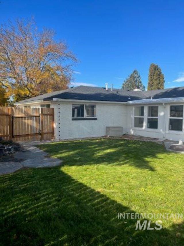 back of house featuring a lawn