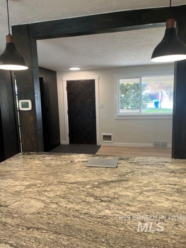 foyer featuring baseboards and visible vents