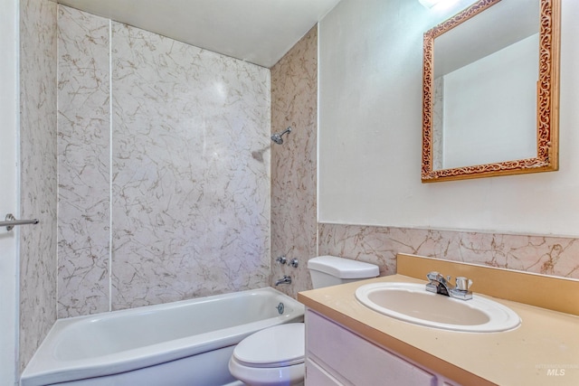 full bath featuring toilet, a wainscoted wall,  shower combination, vanity, and tile walls