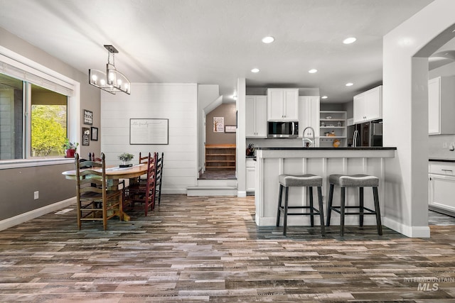 dining area featuring dark wood-style flooring, recessed lighting, baseboards, stairs, and a chandelier