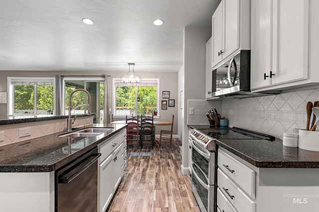 kitchen with stainless steel appliances, a sink, plenty of natural light, baseboards, and recessed lighting
