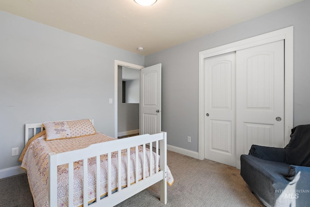 bedroom with light colored carpet, a closet, and baseboards