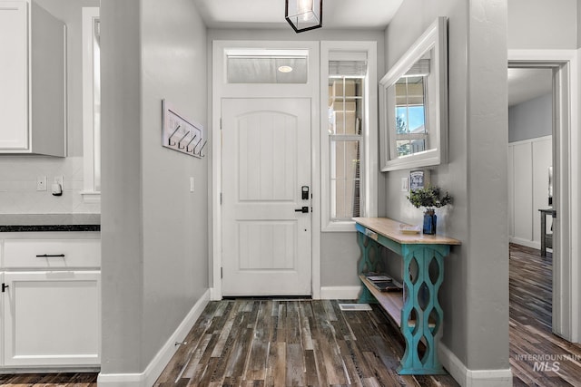 entrance foyer with dark wood-type flooring and baseboards