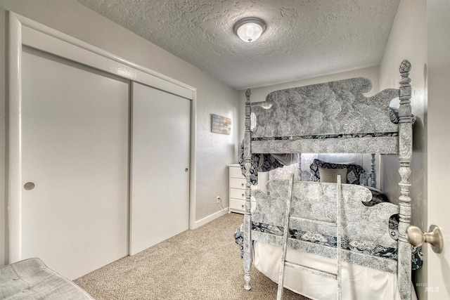 bedroom with a textured ceiling, a closet, and carpet