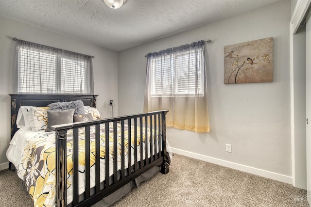 carpeted bedroom featuring baseboards and a textured ceiling