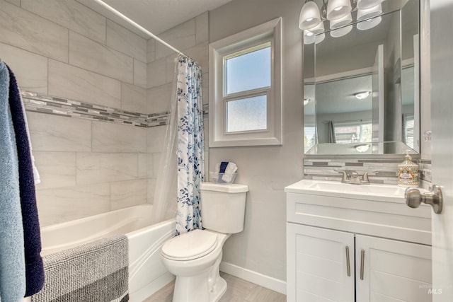 bathroom with shower / tub combo with curtain, vanity, toilet, and baseboards