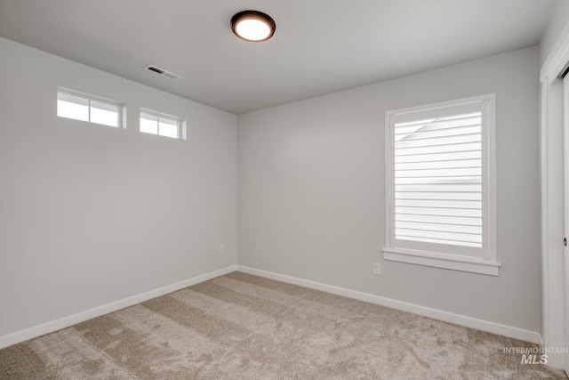 carpeted spare room with baseboards and visible vents
