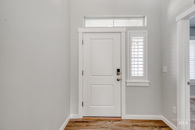 foyer with wood finished floors and baseboards