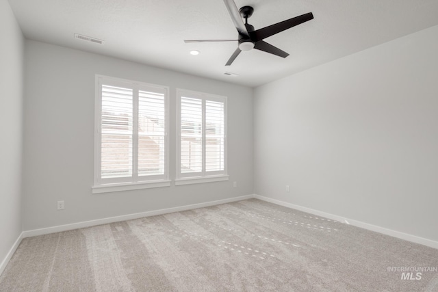 carpeted empty room with a wealth of natural light, baseboards, visible vents, and a ceiling fan