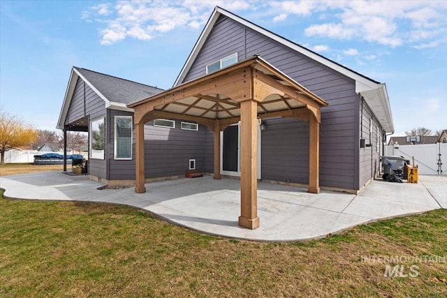 rear view of property featuring a patio area, a yard, fence, and a gazebo