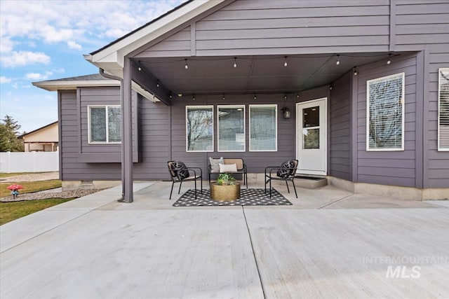 view of patio featuring outdoor lounge area and fence