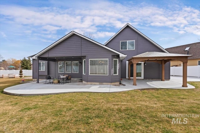 rear view of house featuring a patio area, a gazebo, fence, and a yard