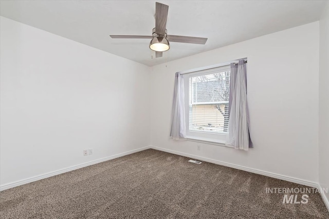 carpeted empty room with visible vents, baseboards, and a ceiling fan