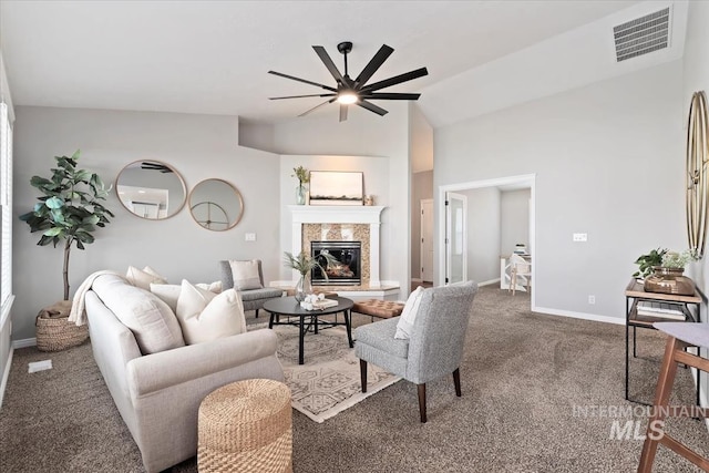 living area featuring a tile fireplace, visible vents, baseboards, vaulted ceiling, and carpet