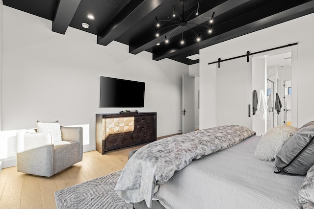 bedroom featuring hardwood / wood-style flooring, a barn door, and beam ceiling