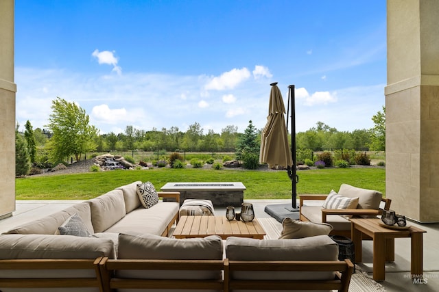 view of patio with an outdoor living space with a fire pit