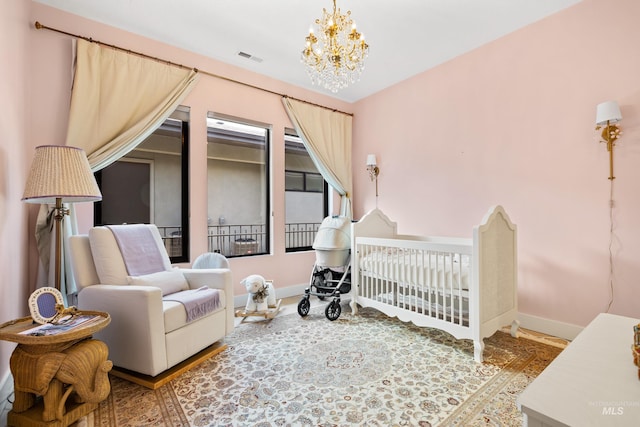 bedroom with a crib and an inviting chandelier