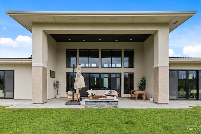 back of house with an outdoor living space, a yard, a patio, and french doors