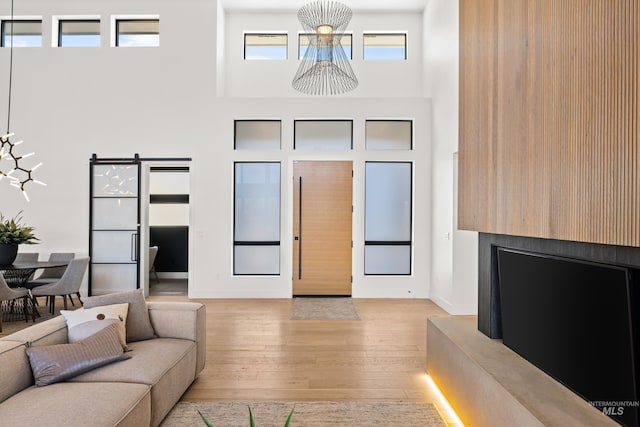 living room with a towering ceiling and light hardwood / wood-style floors