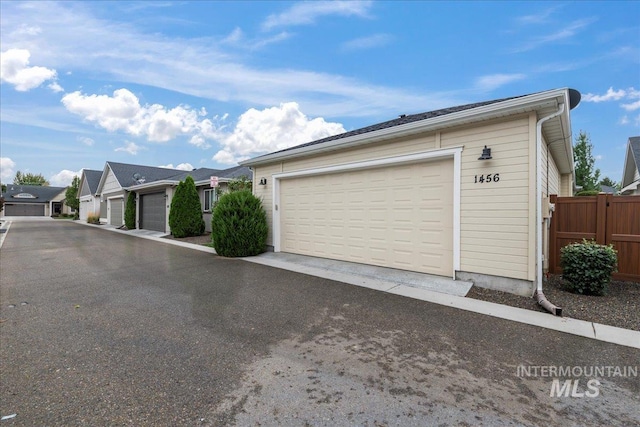 garage featuring fence and a residential view